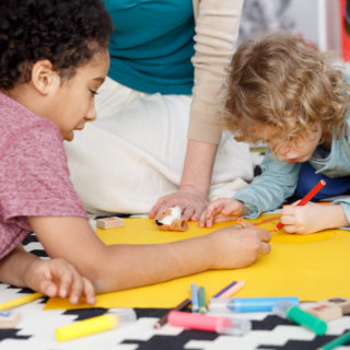 Preschool kids having fun during group painting in kindergarten